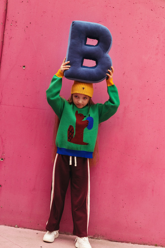 girl on pink wall holding velvet letter cushion b by bettys home over head. letter shaped pillow