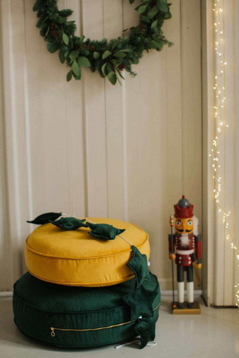 Velvet Star Garland green on small velvet floor pouf during christmas time 